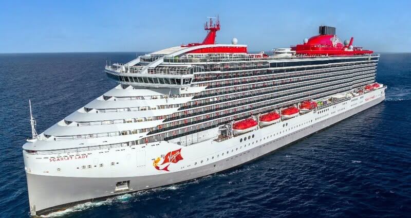 Virgin Voyages Scarlet Lady cruise ship sails across open ocean.