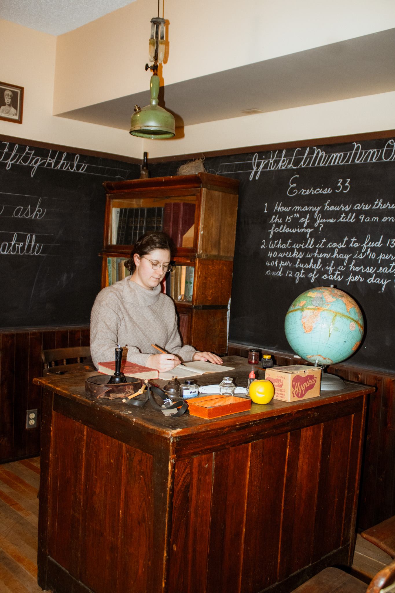 Historic classroom display at Millet Museum with wooden desk, chalkboards, and globe.