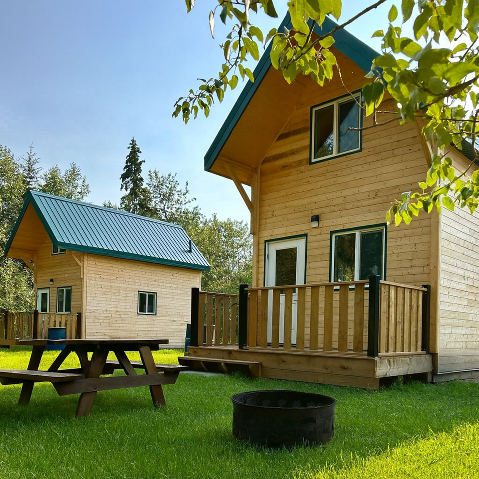 2 Knotty Pine Cabins with picnic table and fire ring and lush green grass