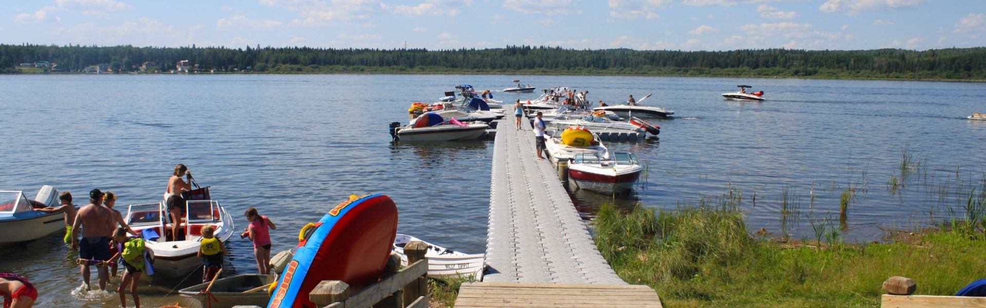 Visitors enjoy boating and swimming near a busy dock at Wabamun Lake Provincial Park