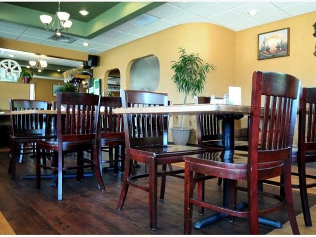 Cozy dining area at Las Palmeras with wooden tables, chairs, and warm lighting.