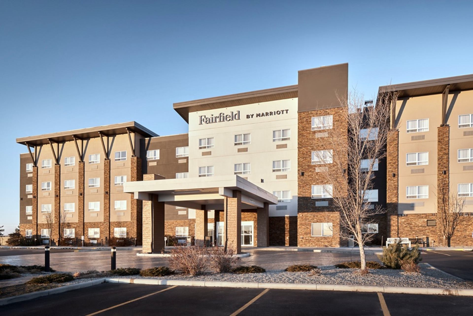 Fairfield by Marriott hotel exterior with covered entrance and empty parking lot.