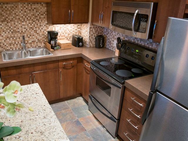 Modern lodge kitchen with granite counters, stainless appliances, and wood cabinets.