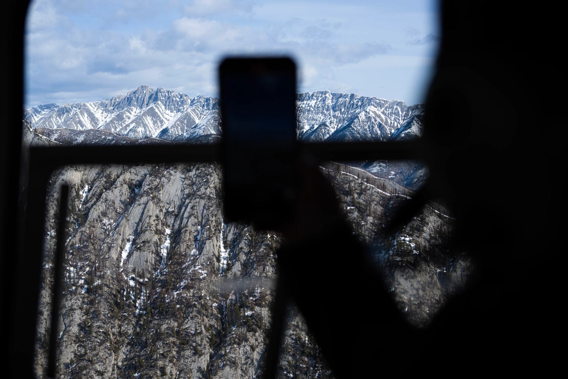 Helicopter flying over scenic landscapes of rivers, forests, and mountains.
