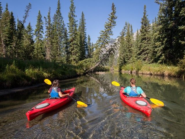 Two women kayaking down a river.