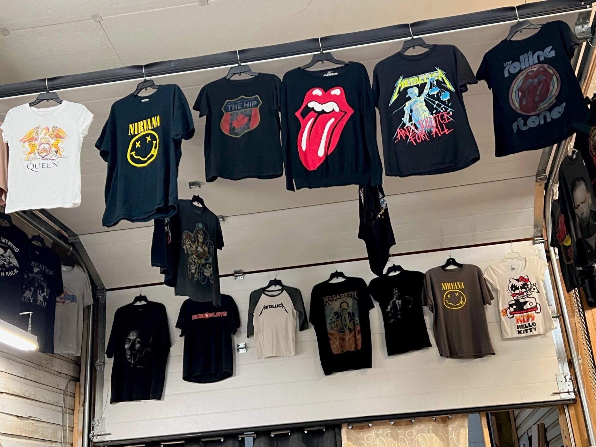 Wall display of graphic T-shirts featuring band logos and vintage designs at The Treasure Chest.