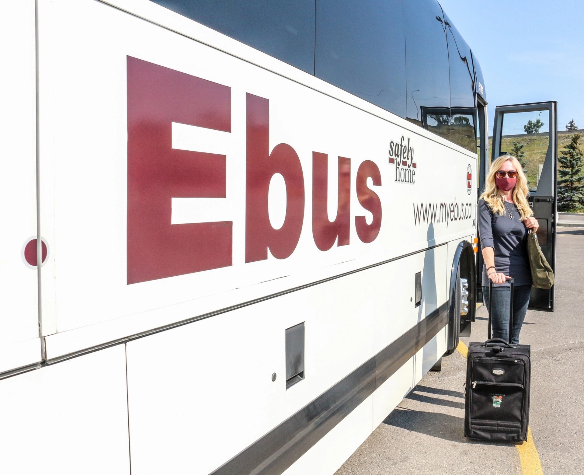 Person with suitcase boarding an Ebus.
