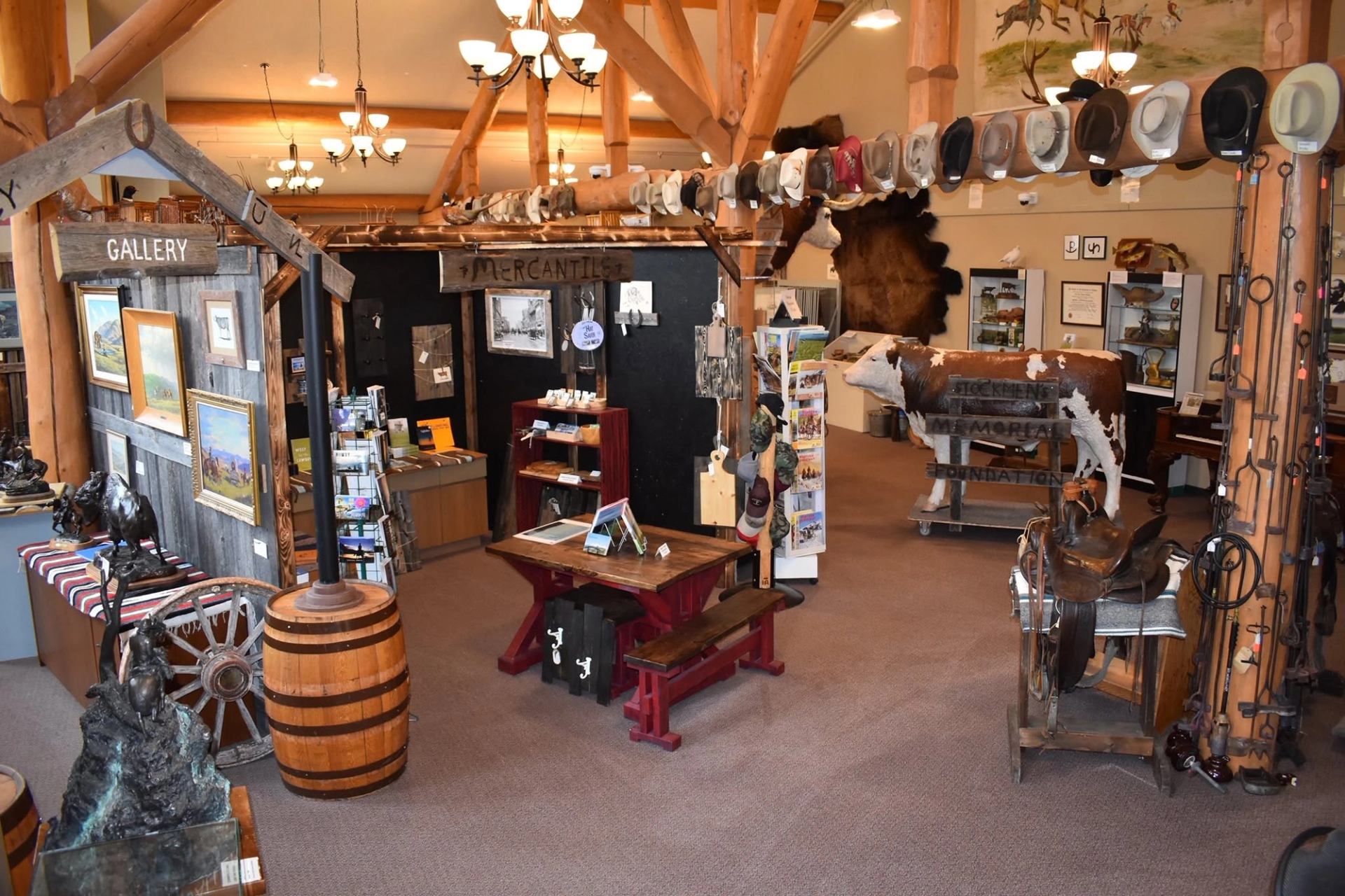 Museum exhibits feature western artifacts, cowboy hats, saddles, artwork, and historical displays throughout the gallery.