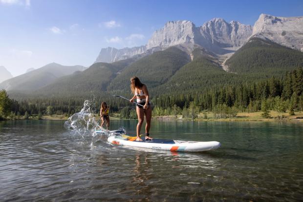 People stand up paddle boarding on Quarry Lake in Canmore.