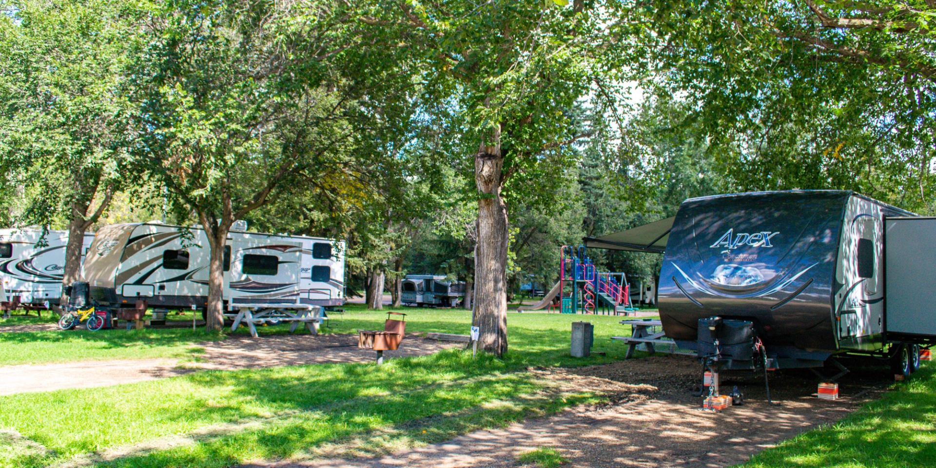A generic campground image with a few RV trailers and a playground in the background