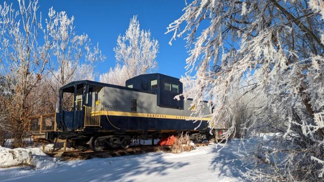 Exterior of an Aspen Crossing Caboose Cabin during winter.