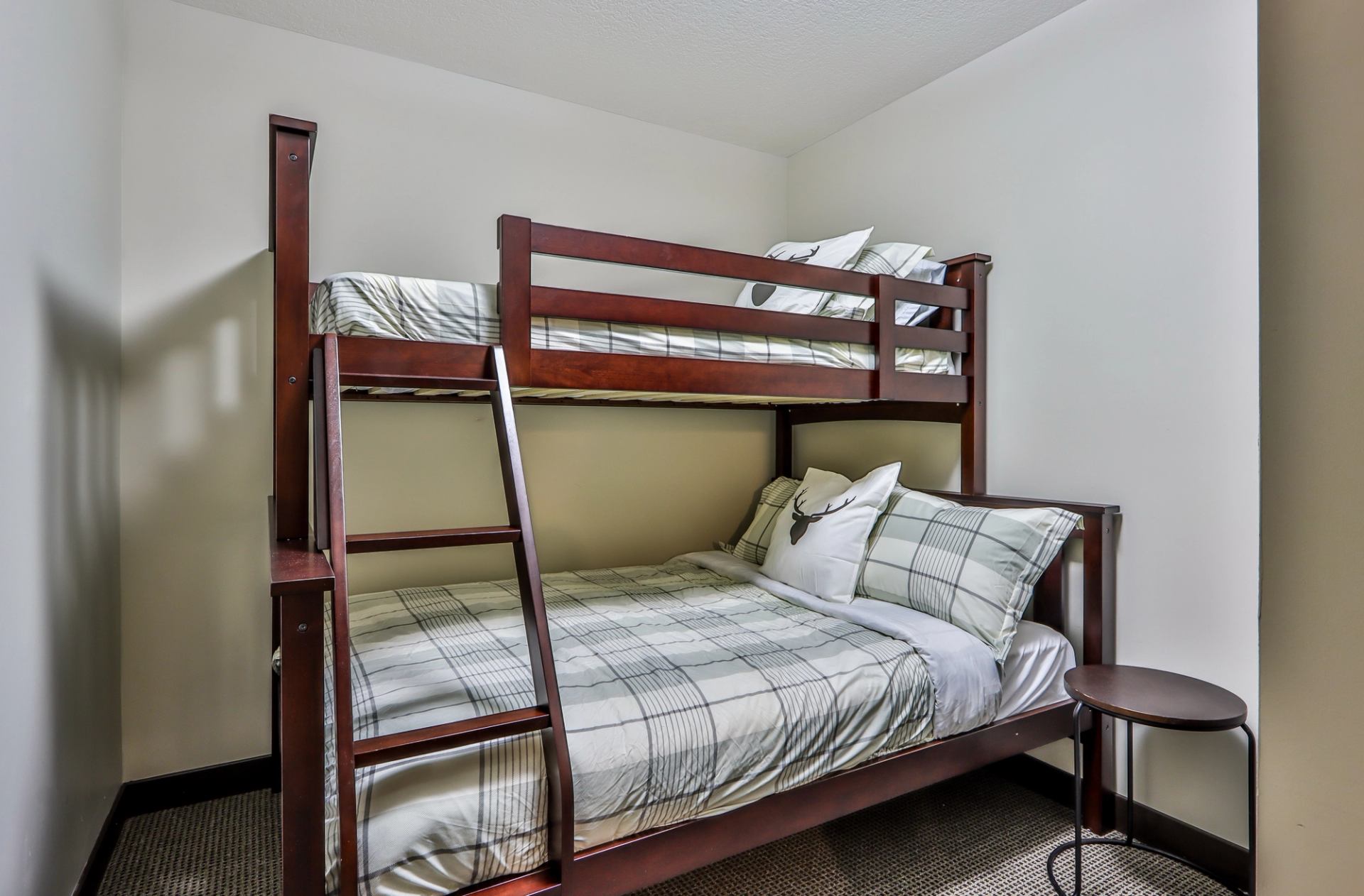 Neatly made wooden bunk beds with plaid bedding in a guest room at Scenic Mountain Resort.
