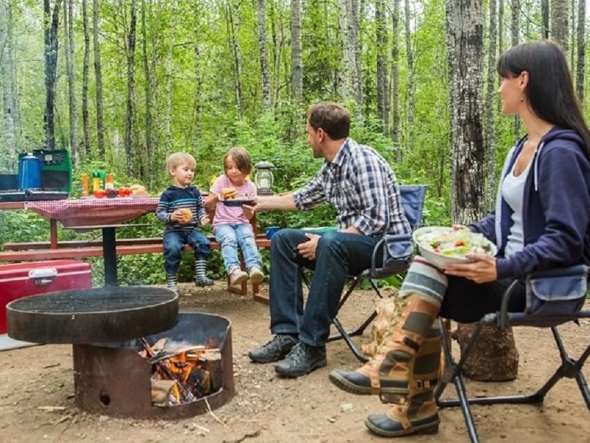 A young family enjoying a meal in their campsite at Marten River.