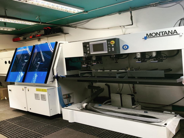 High-tech MONTANA machine with dual screens and control panel in industrial setting.