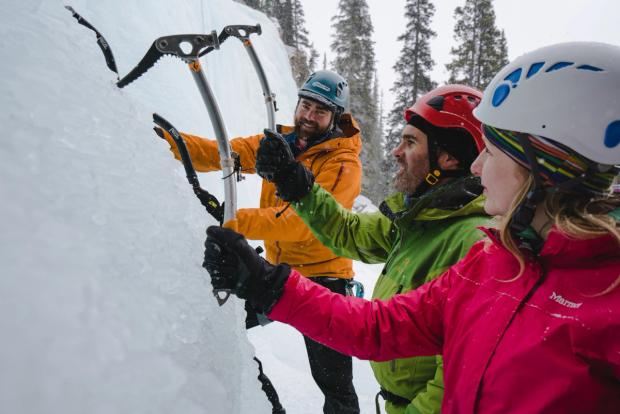 An ice climbing guide teaching a group how to use their ice picks at Tangle Falls in Jasper National Park