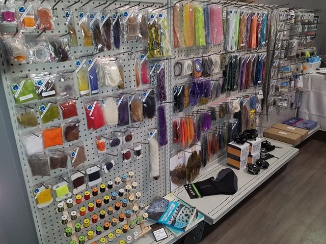 Wall display of fly fishing materials and gear in the store.