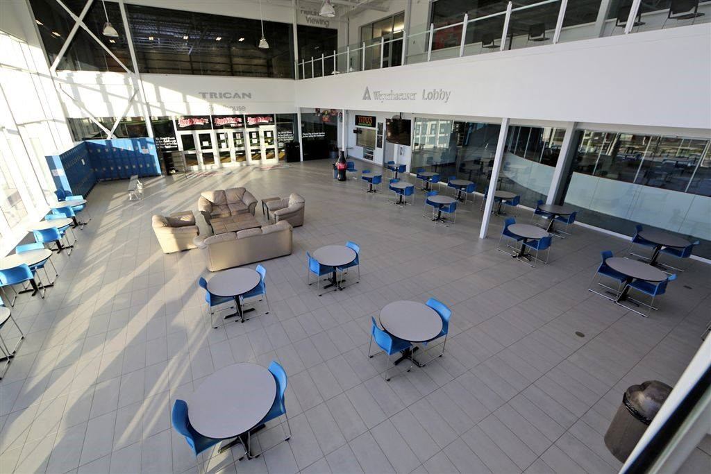Lobby seating area with blue chairs, round tables, couches and Weyerhaeuser Lobby sign.