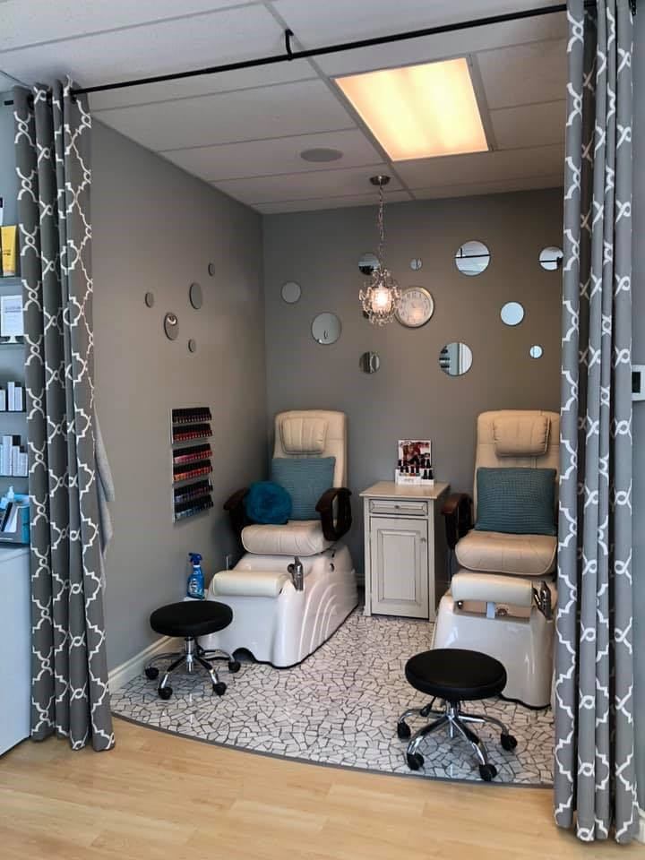 Spa room with two pedicure chairs, foot basins, stools and round wall mirrors.