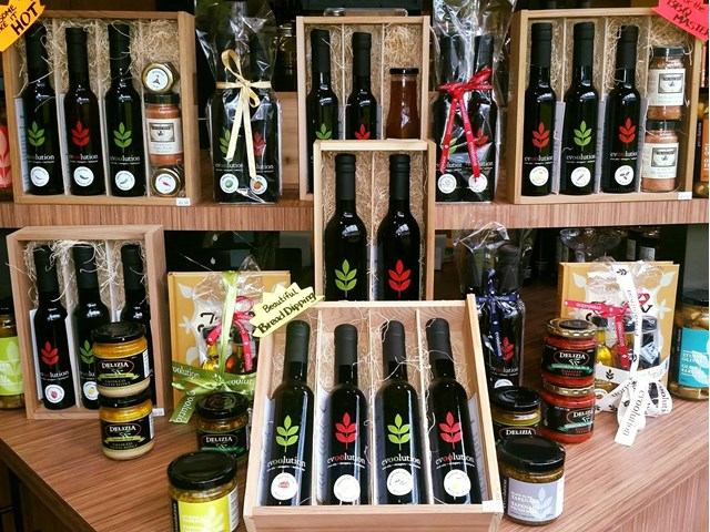 Display of bottled olive oil and packaged food items in a retail store shelf, Edmonton.
