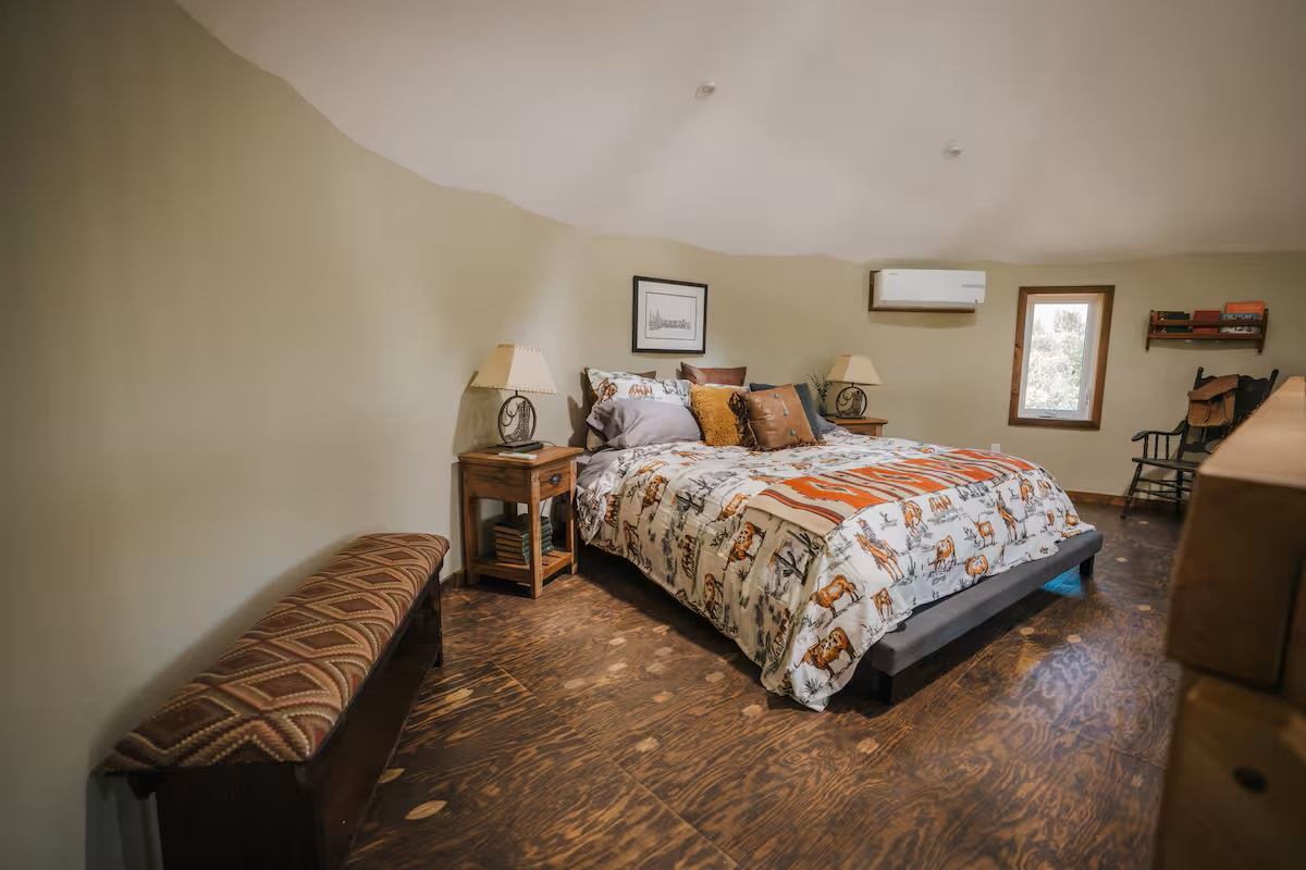 Saddle Hill Ranch bedroom with patterned bedding, wood floors, and rustic decor.