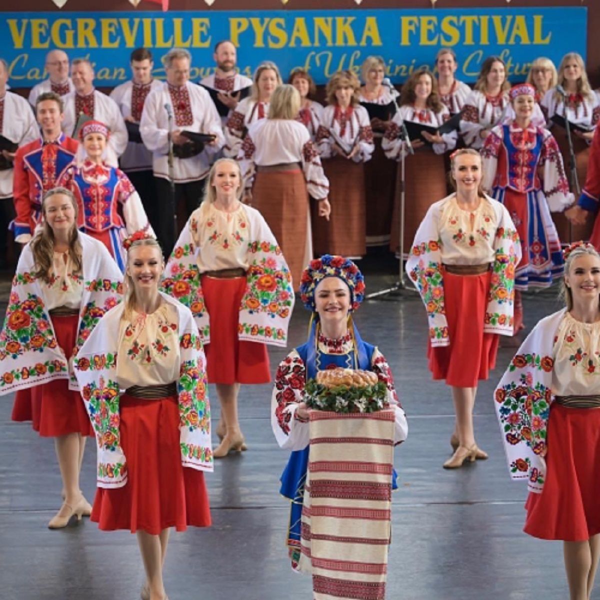 Women in traditional Ukrainian embroidered blouses and red skirts perform.