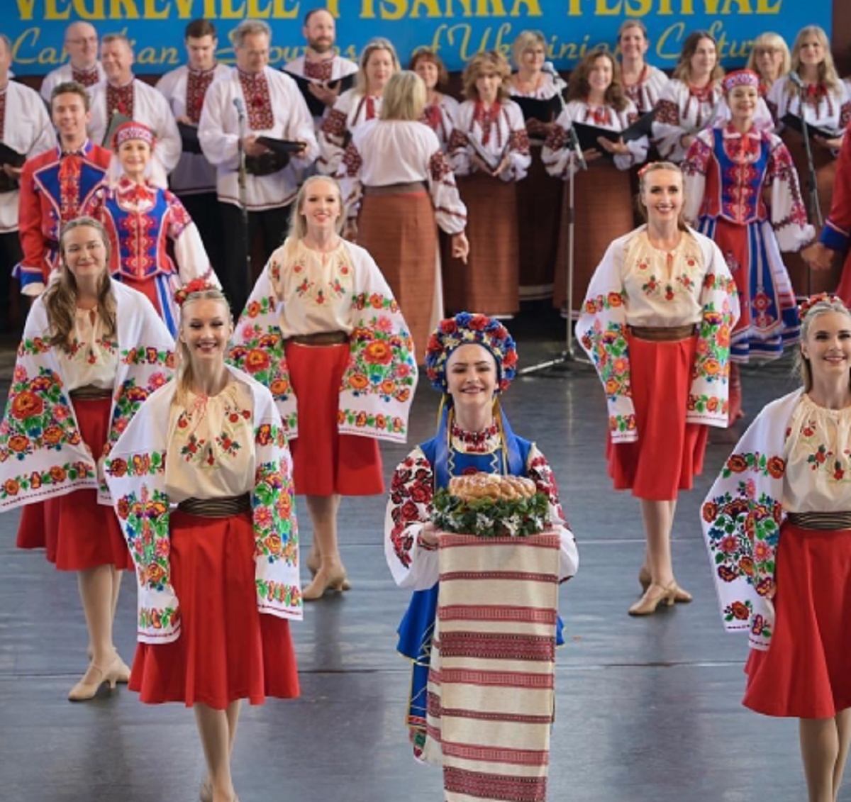 Women in traditional Ukrainian embroidered blouses and red skirts perform.