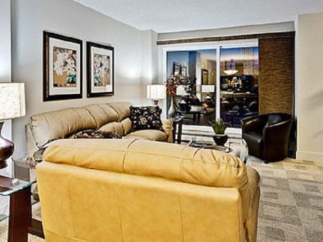 Modern living room with leather sofas and city view at Corporate Suites of Calgary.