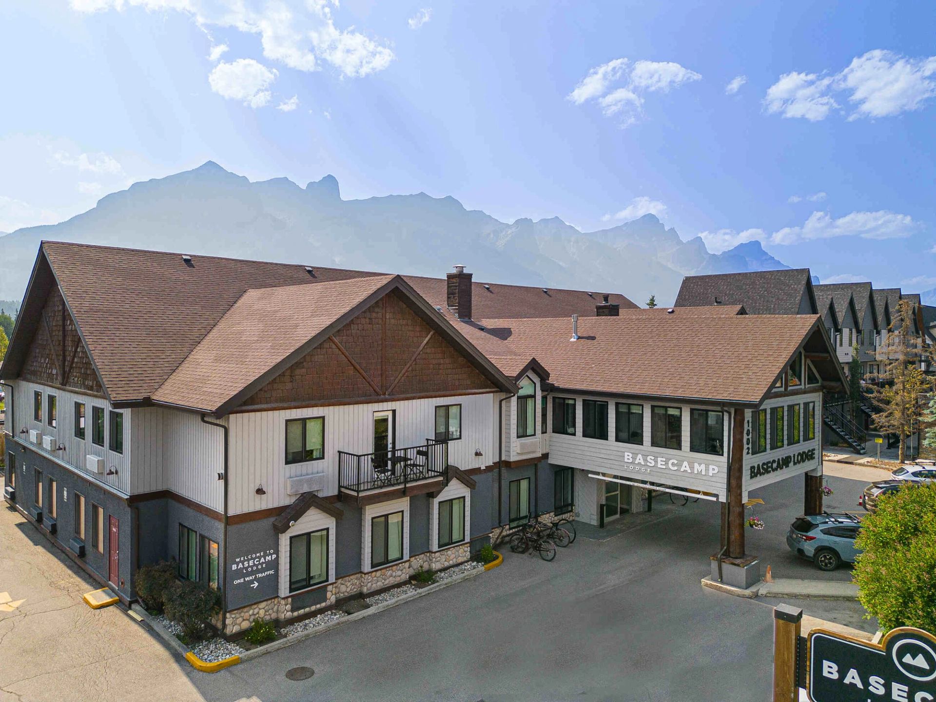Basecamp Lodge Canmore buildings with balconies, mountain views, and on-site parking signs.