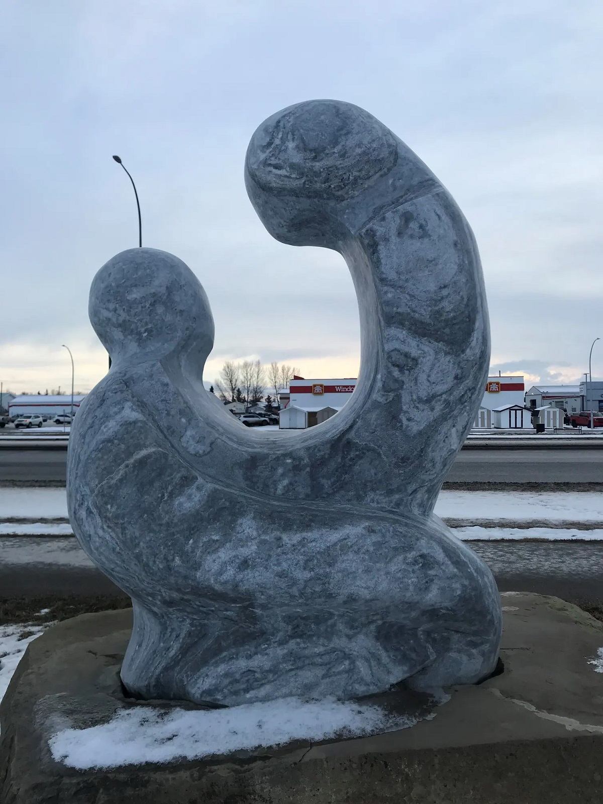 Stone sculpture of two people embracing.