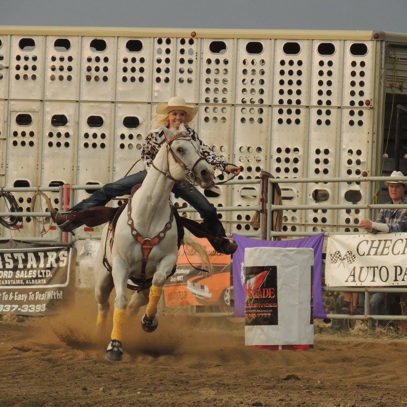 A cowgirl riding her horse for the barrel racing competition.
