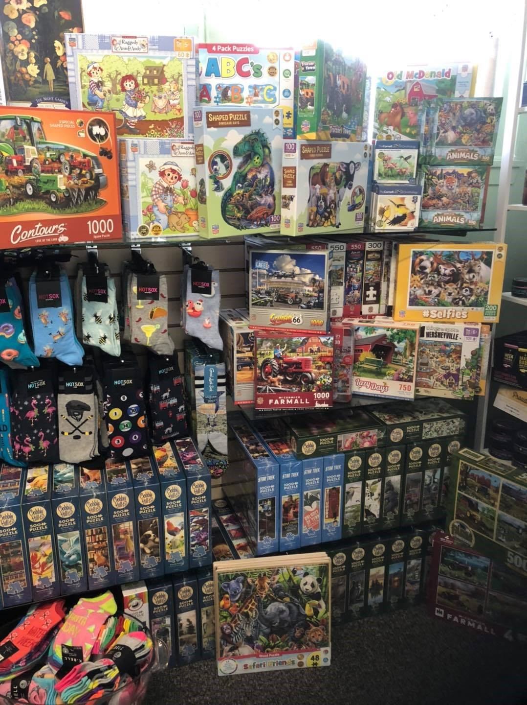 Puzzles and novelty items displayed on shelves inside a retail shop in Edmonton.