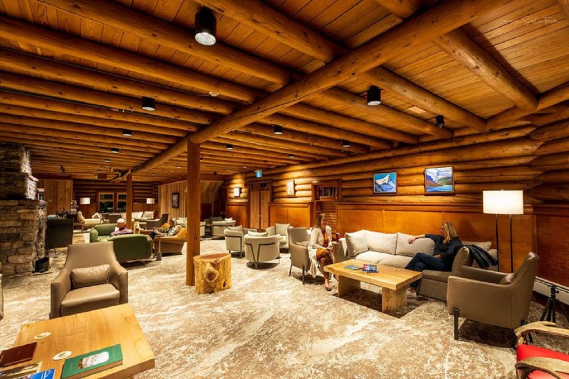 The rustic living room area with exposed beams and plenty of sitting spaces for large groups. 