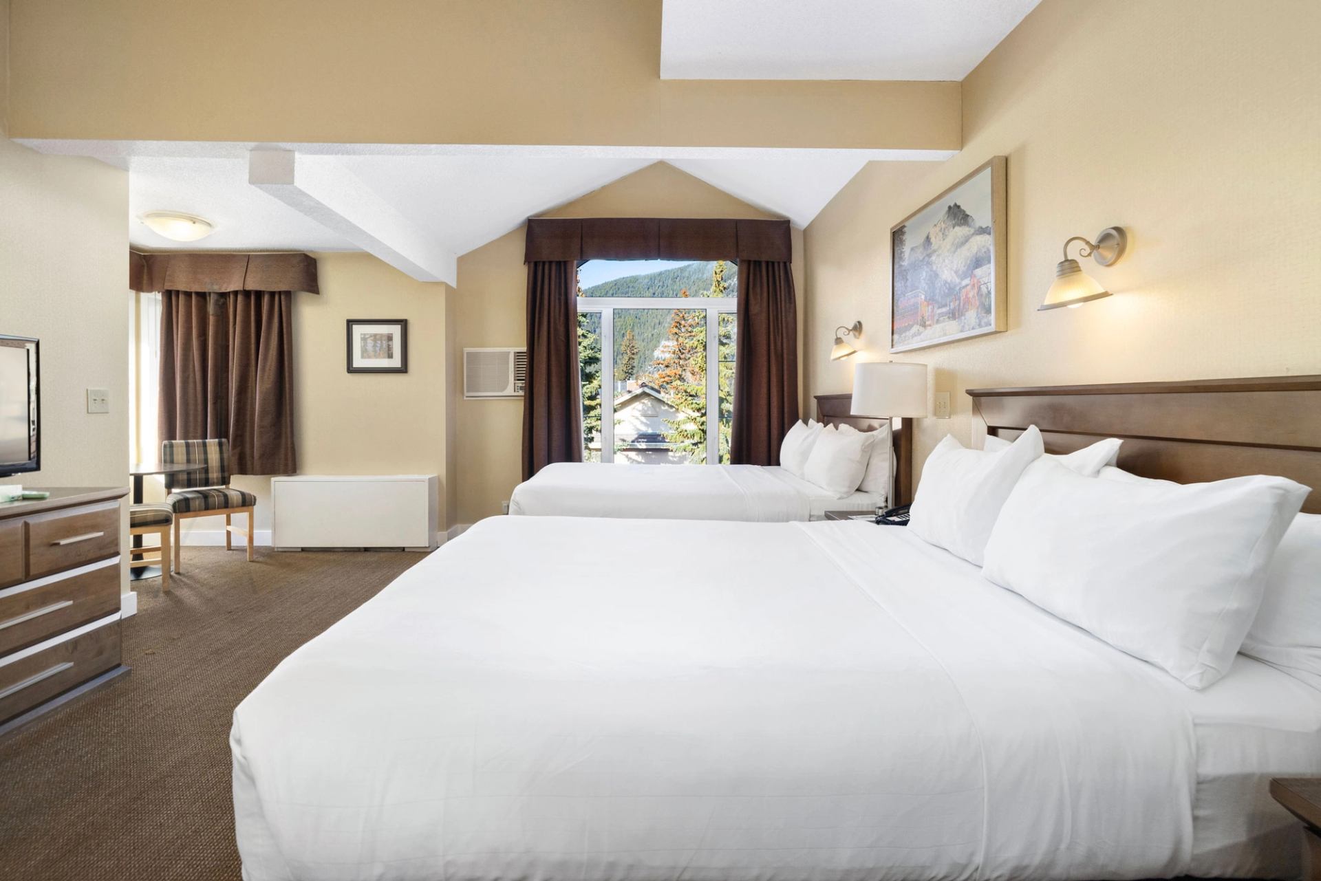 Cozy hotel room with two beds, balcony access, and modern amenities.