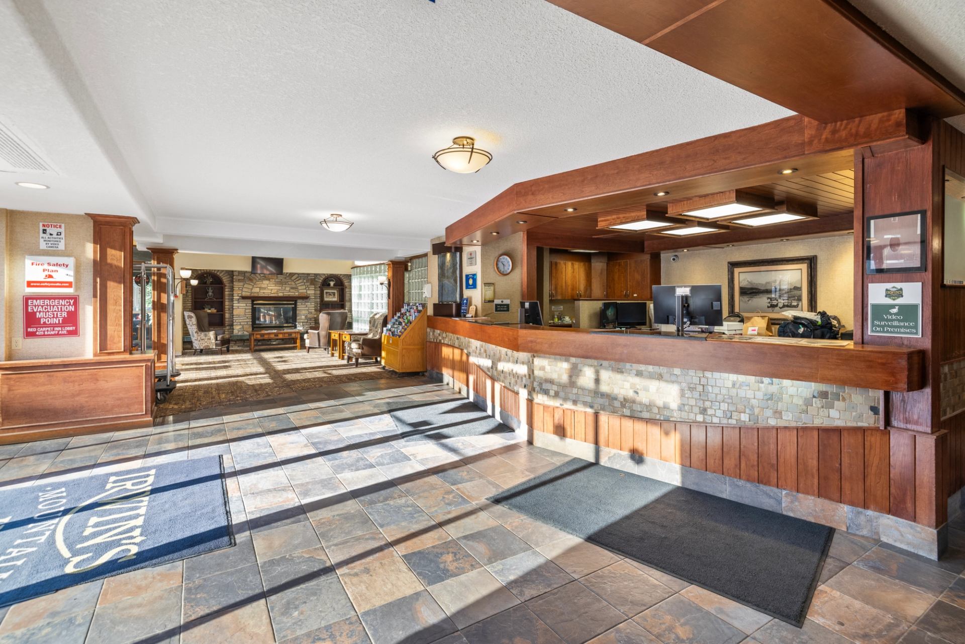 Warm hotel lobby with stone reception desk, cozy seating, and rustic decor.