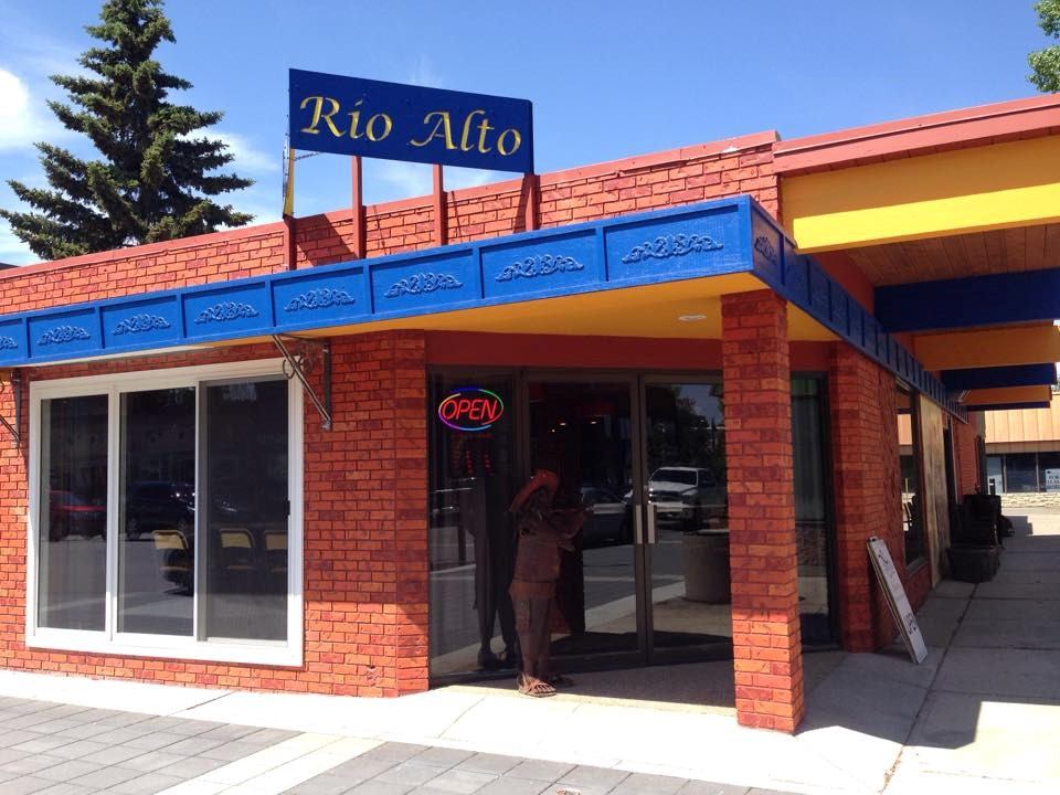 Exterior of Rio Alto Mexican Restaurant with red brick walls and blue trim.