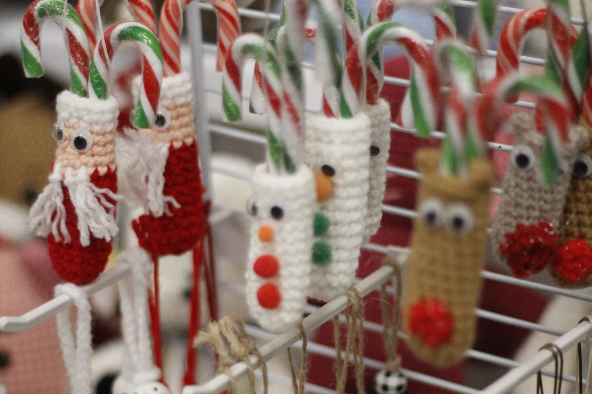 Crocheted candy cane covers shaped like Santa, snowman, and reindeer in festive detail.