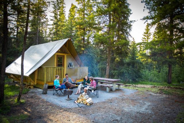 Friends comfort camping in an oTENTik canvas tent at Whistlers Campground in Jasper National Park.