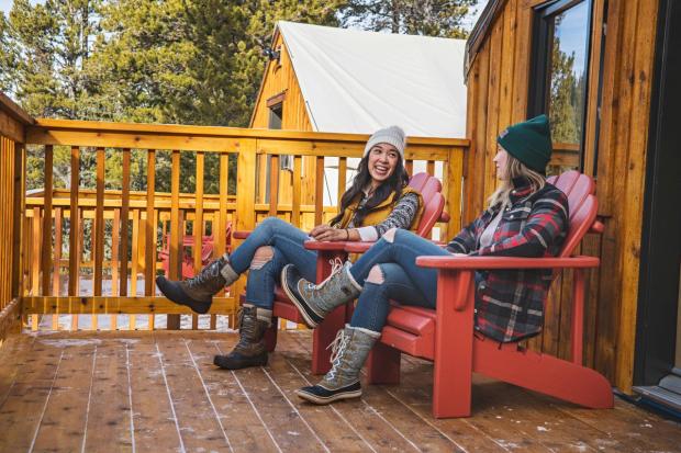 Friends sitting on the porch while winter camping at Mt.Engadine Lodge in Kananaskis Country.