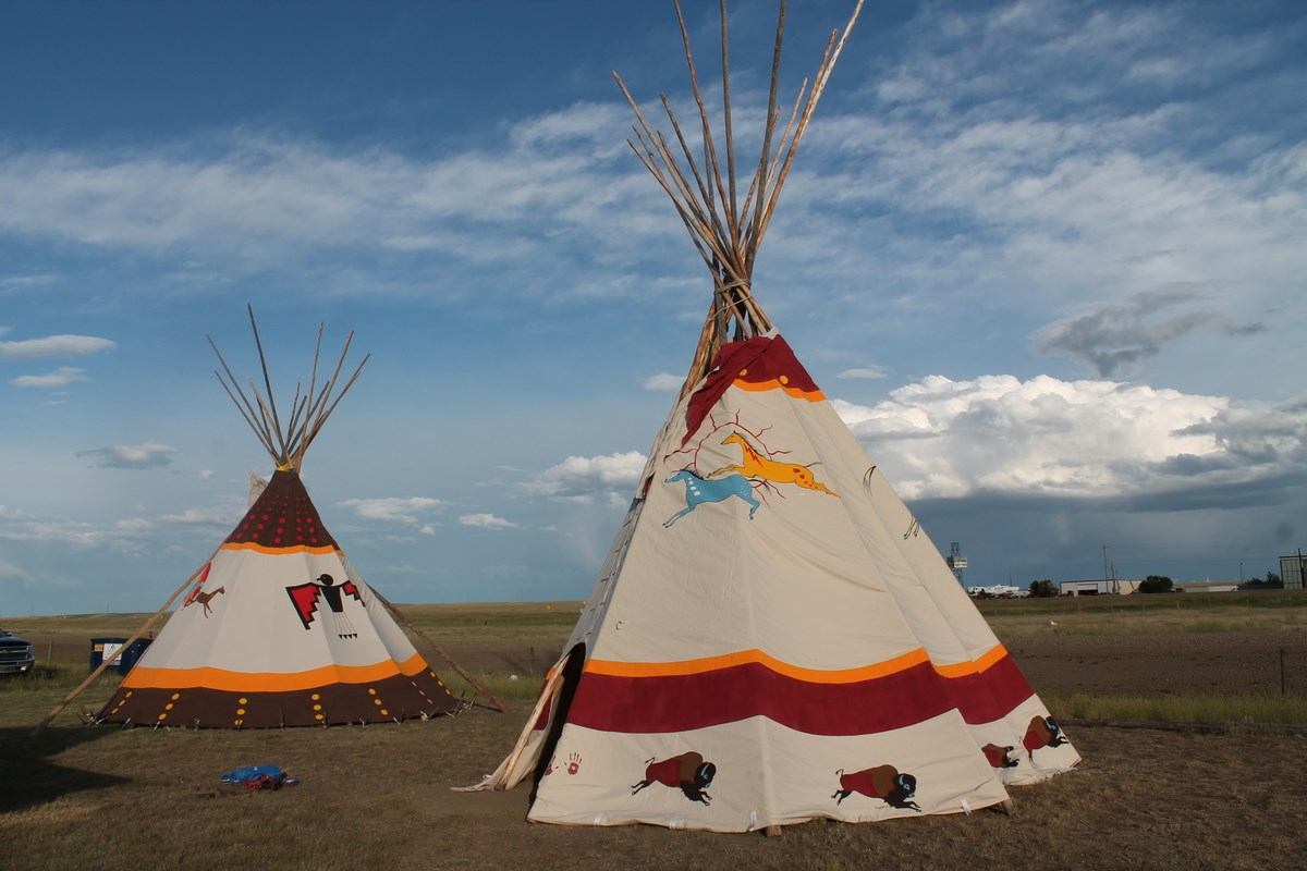 Two tipis in a field.