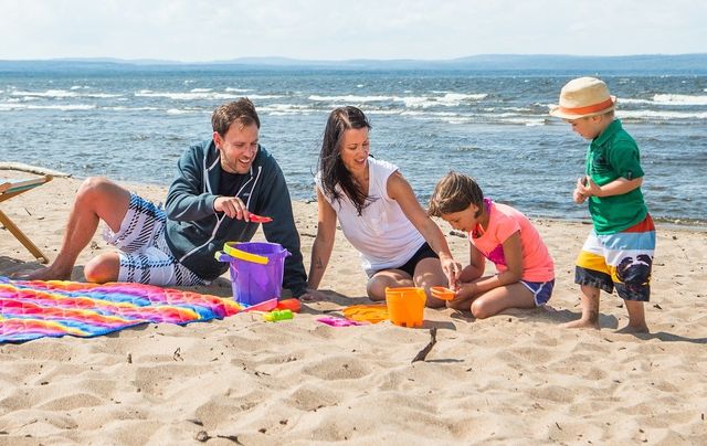 Family building a sand castle on the beach.