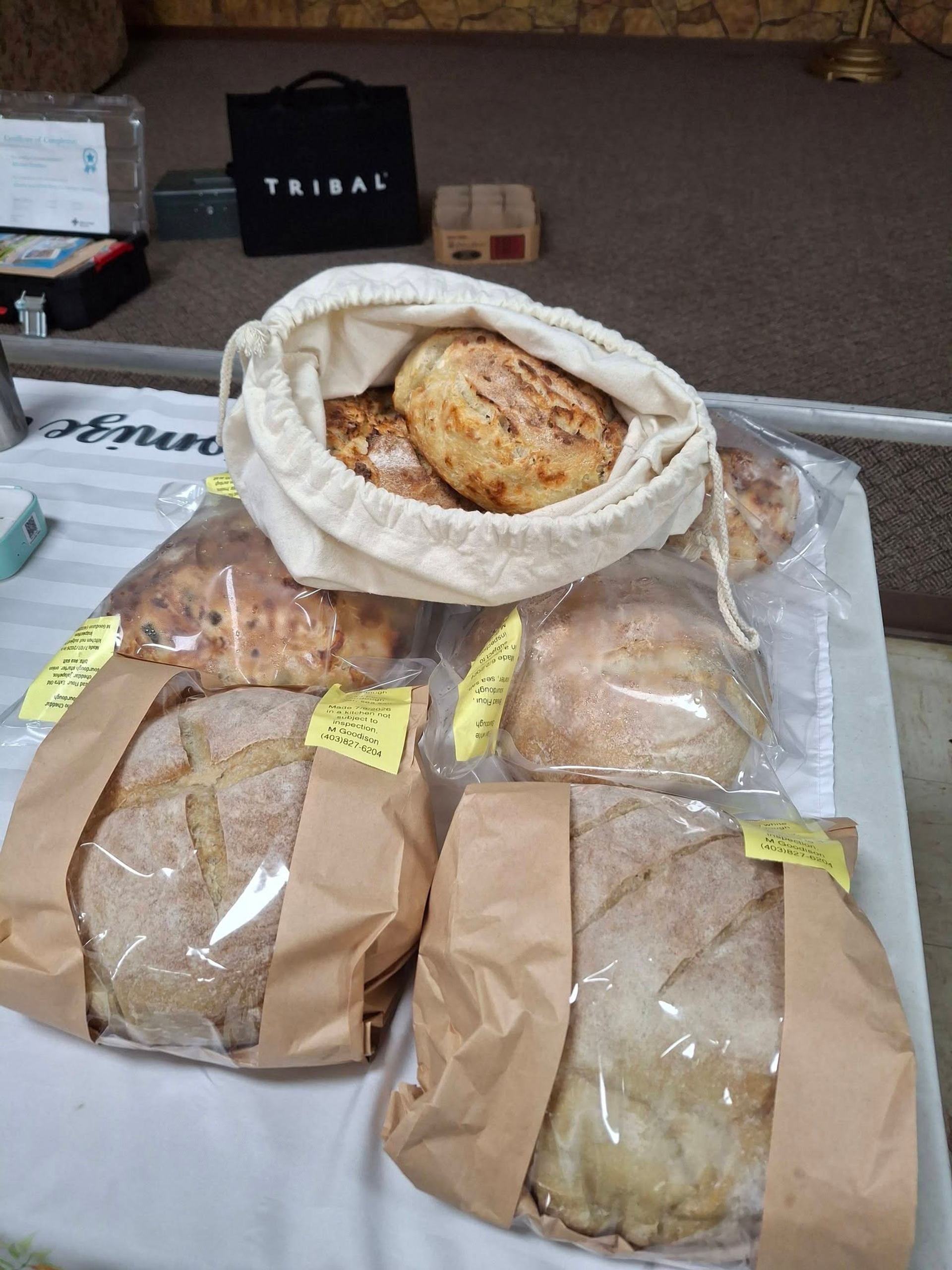 Vegreville Farmers' Market showcases artisan breads displayed in bags and baskets at a vendor table.