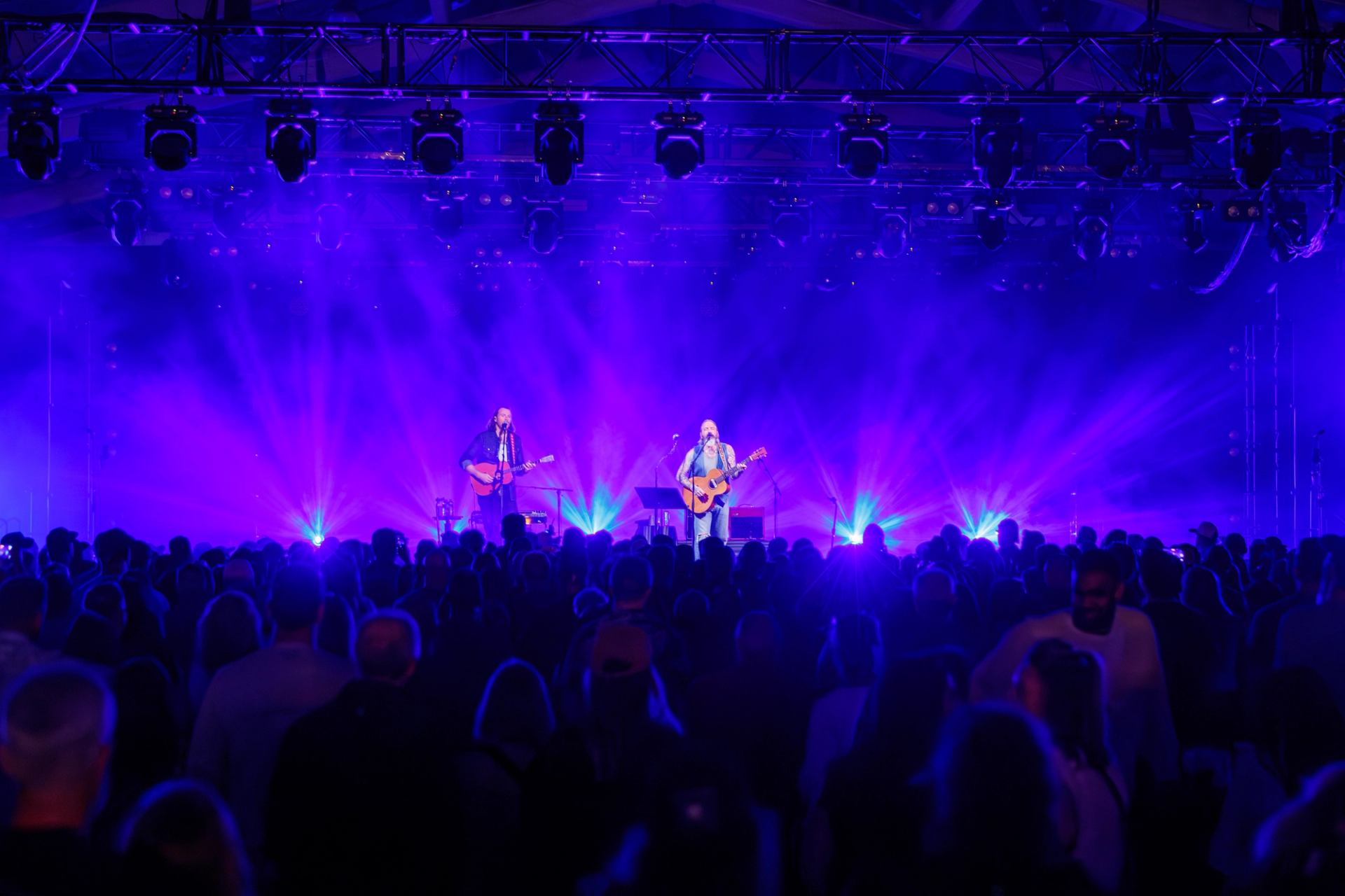 Sam Roberts Band performing onstage with bright blue and purple lights before a large crowd. 