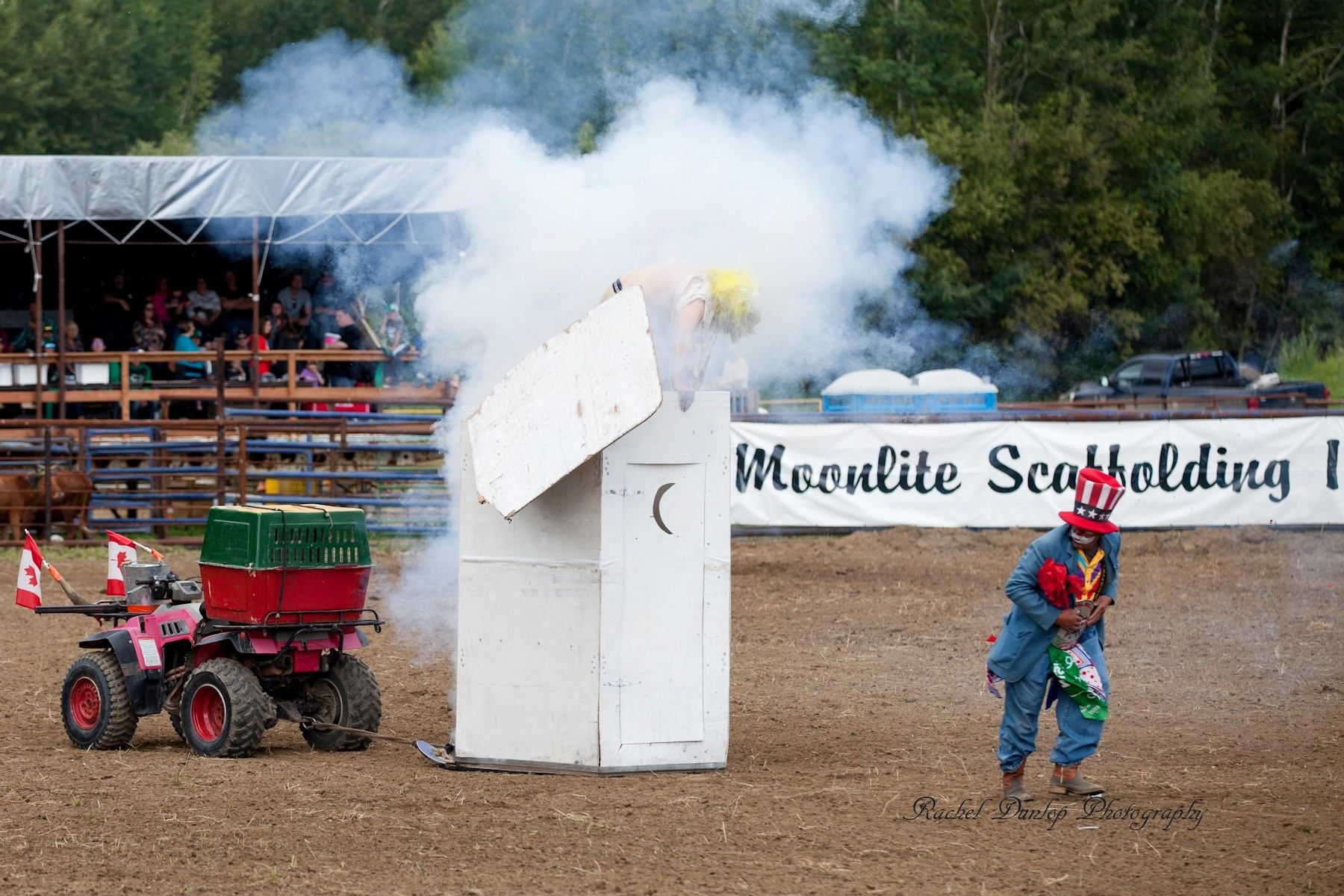 Rodeo entertainer amid smoke beside a prop explosion at Wildrose Rodeo arena.