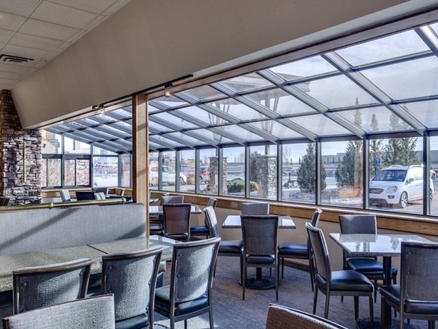 Cozy cafe seating by large glass windows with outdoor views.