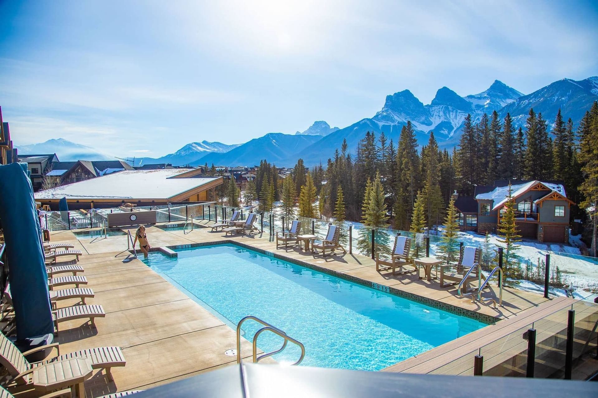 The pool at The Malcolm Hotel with seating around it and mountain views in the background.