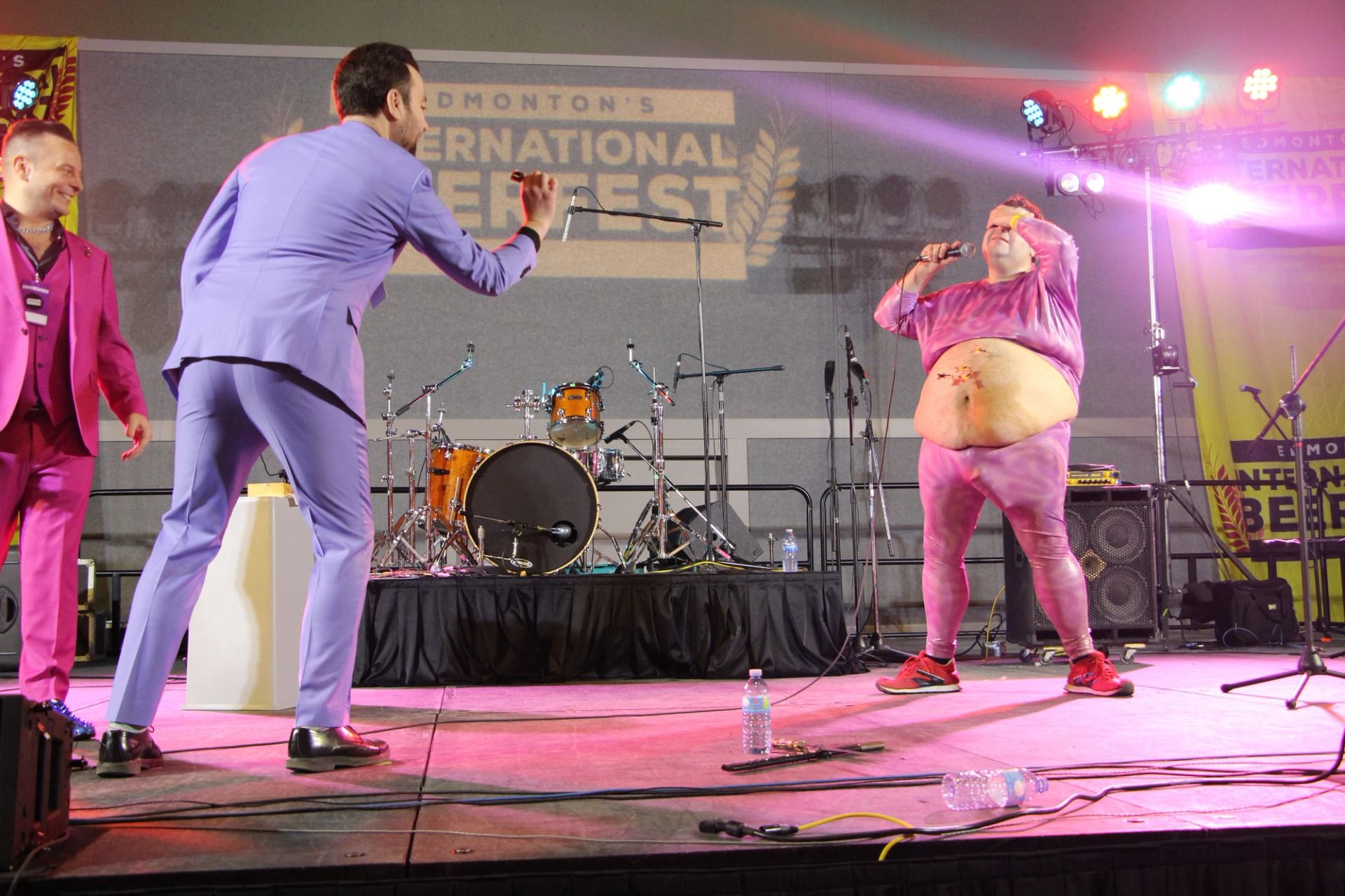 Two performers in colorful suits interact on stage at Edmonton’s International Beerfest.