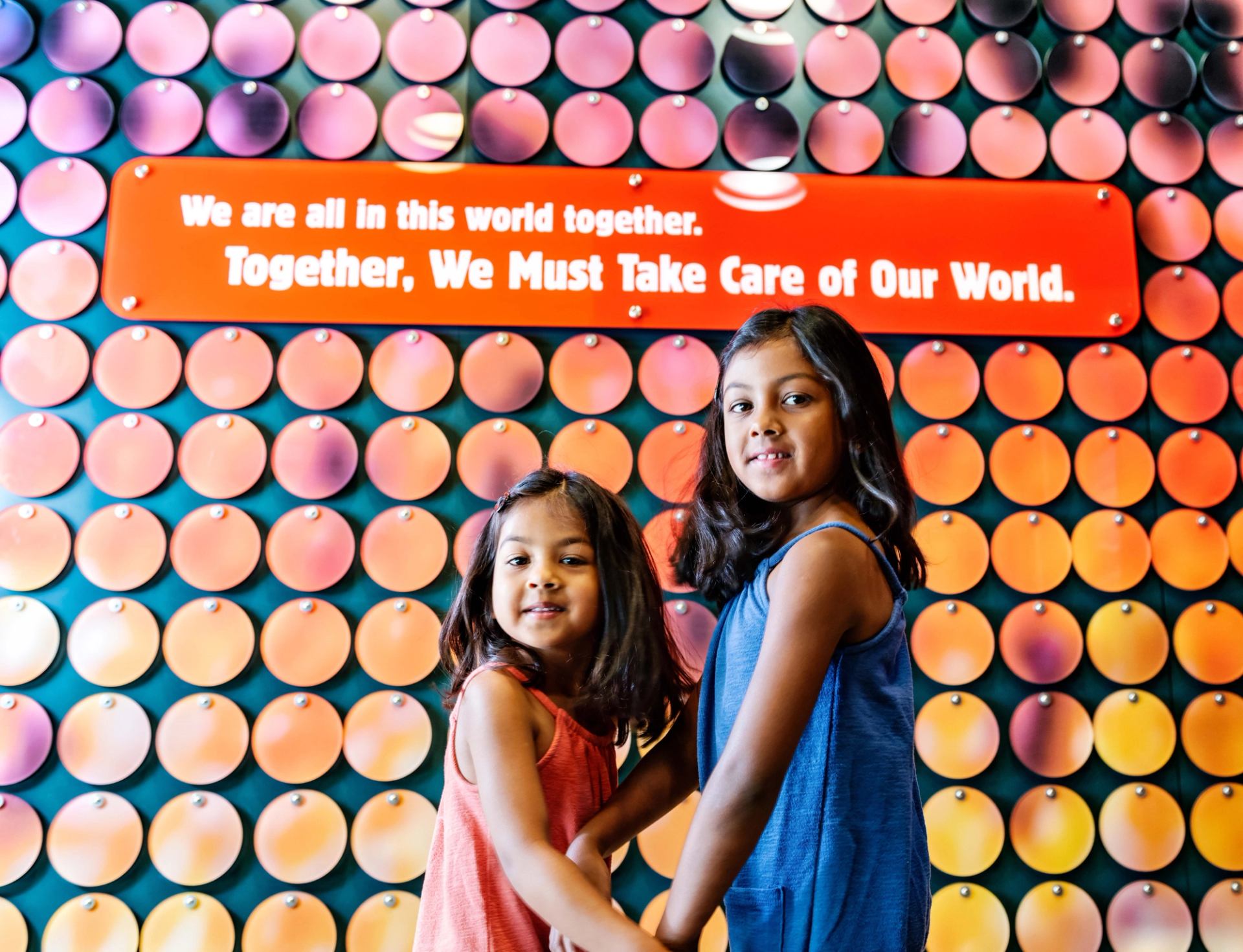 Colorful wall display with circular patterns and a bold environmental message.