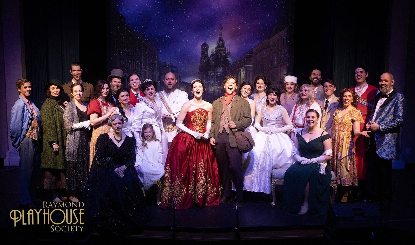 Cast in period costumes on stage with starry night backdrop at Raymond Broadway Theatre.