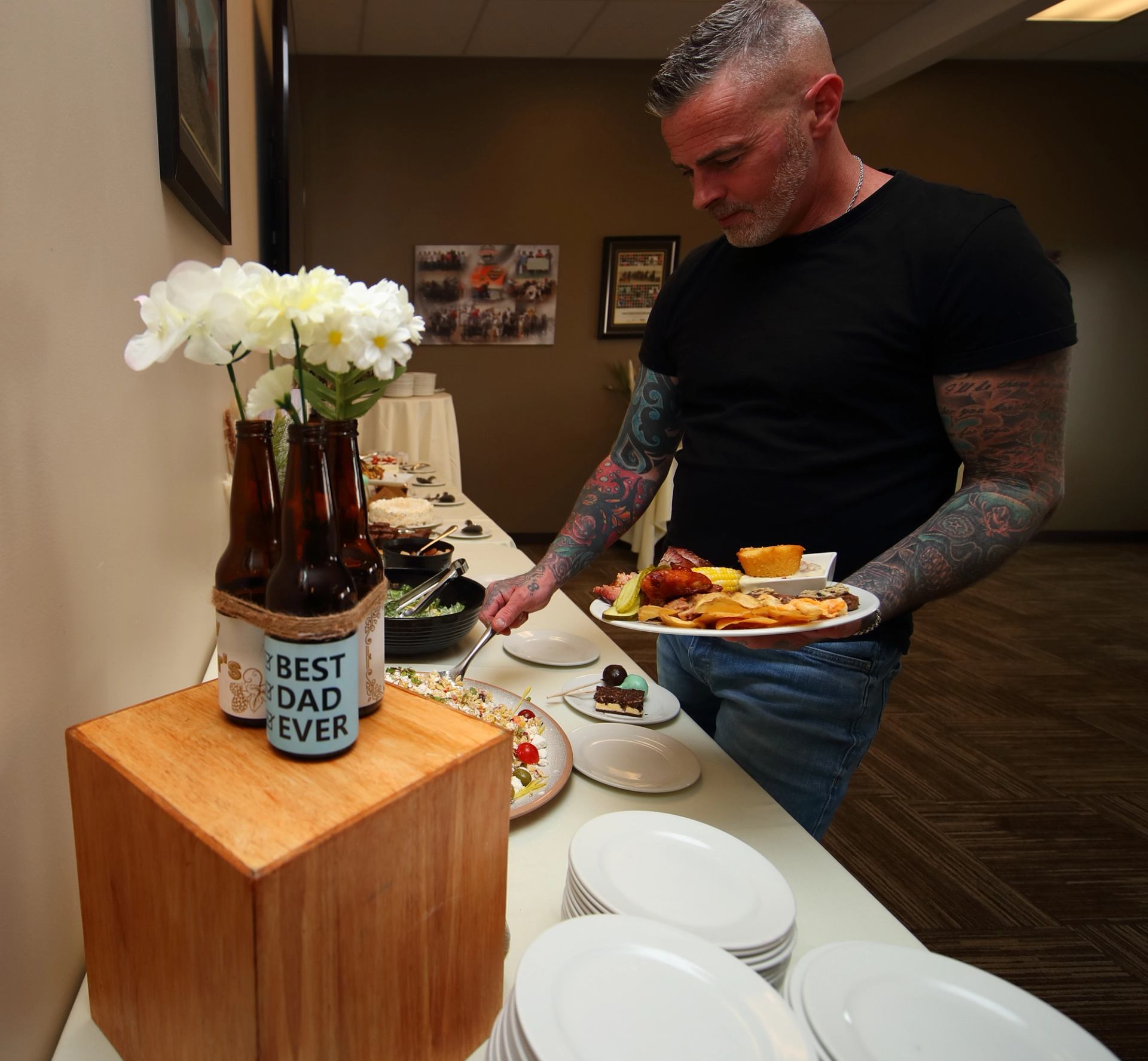Buffet table with food and a display featuring Best Dad Ever bottles