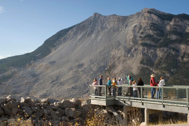 A group of visitors at a lookout point observing Frank Slide in the Crowsnest Pass.